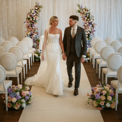 Elegant wedding ceremony with bride and groom in a beautifully decorated hotel venue, surrounded by floral arrangements.