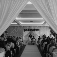 Elegant banquet hall set for a wedding ceremony with floral decor and sparkling lights at luxury hotel venue.