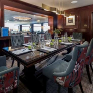 Elegant meeting room with plush chairs, wooden table, and floral decor in luxury hotel for business gatherings.